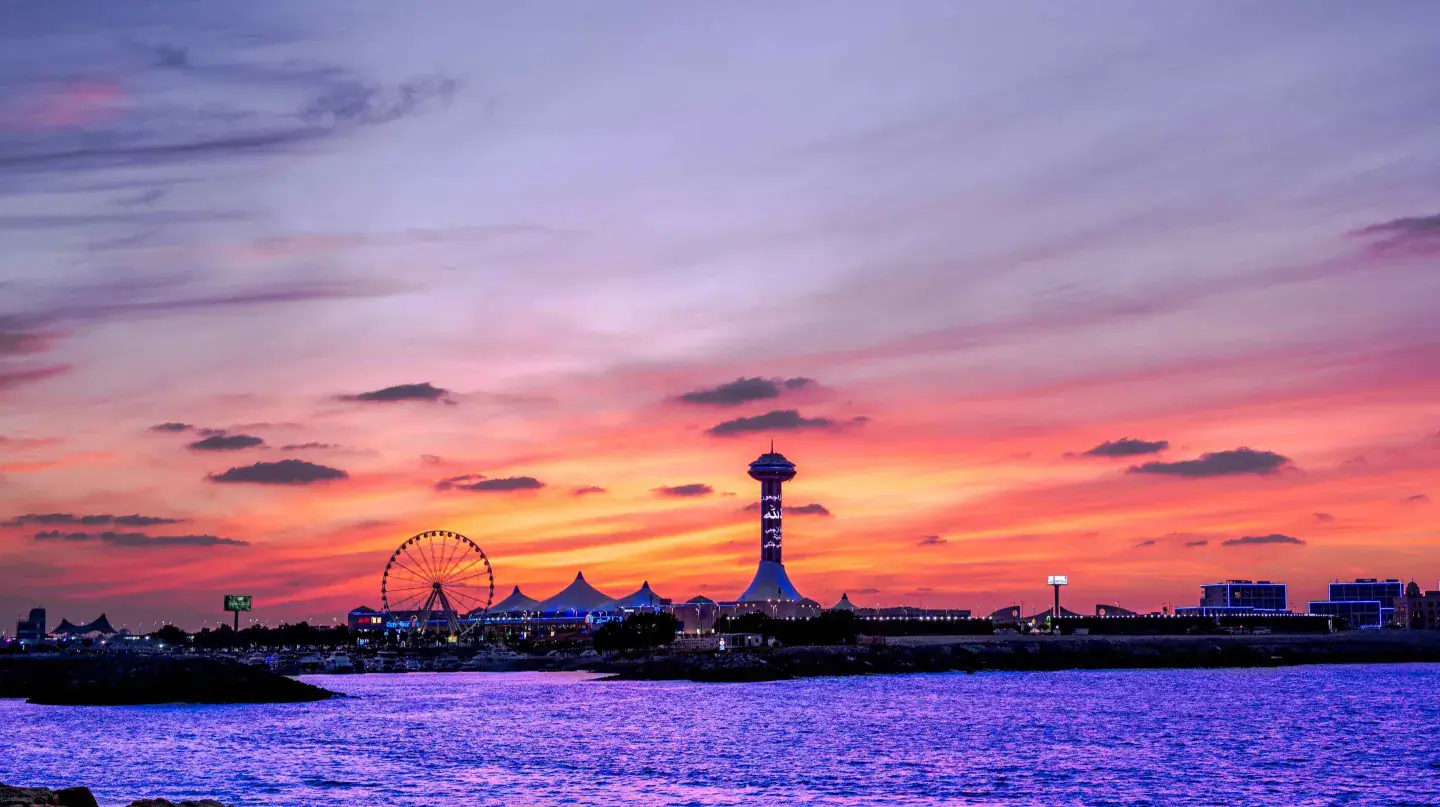 Abu Dhabi Breakwater at sunset, with Marina Mall tower, the observation wheel and the flagpole