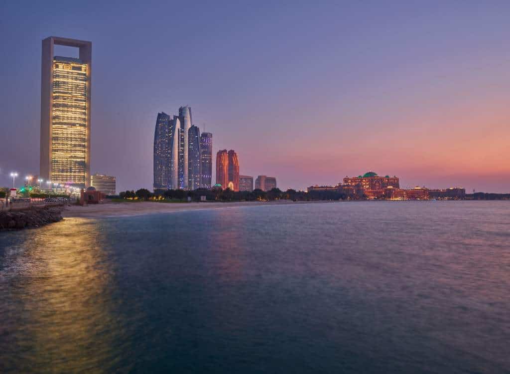 Al Corniche Abu Dhabi at sunset, with ADNOC HQ, Etihad Towers and Emirates Palace on the waterfront