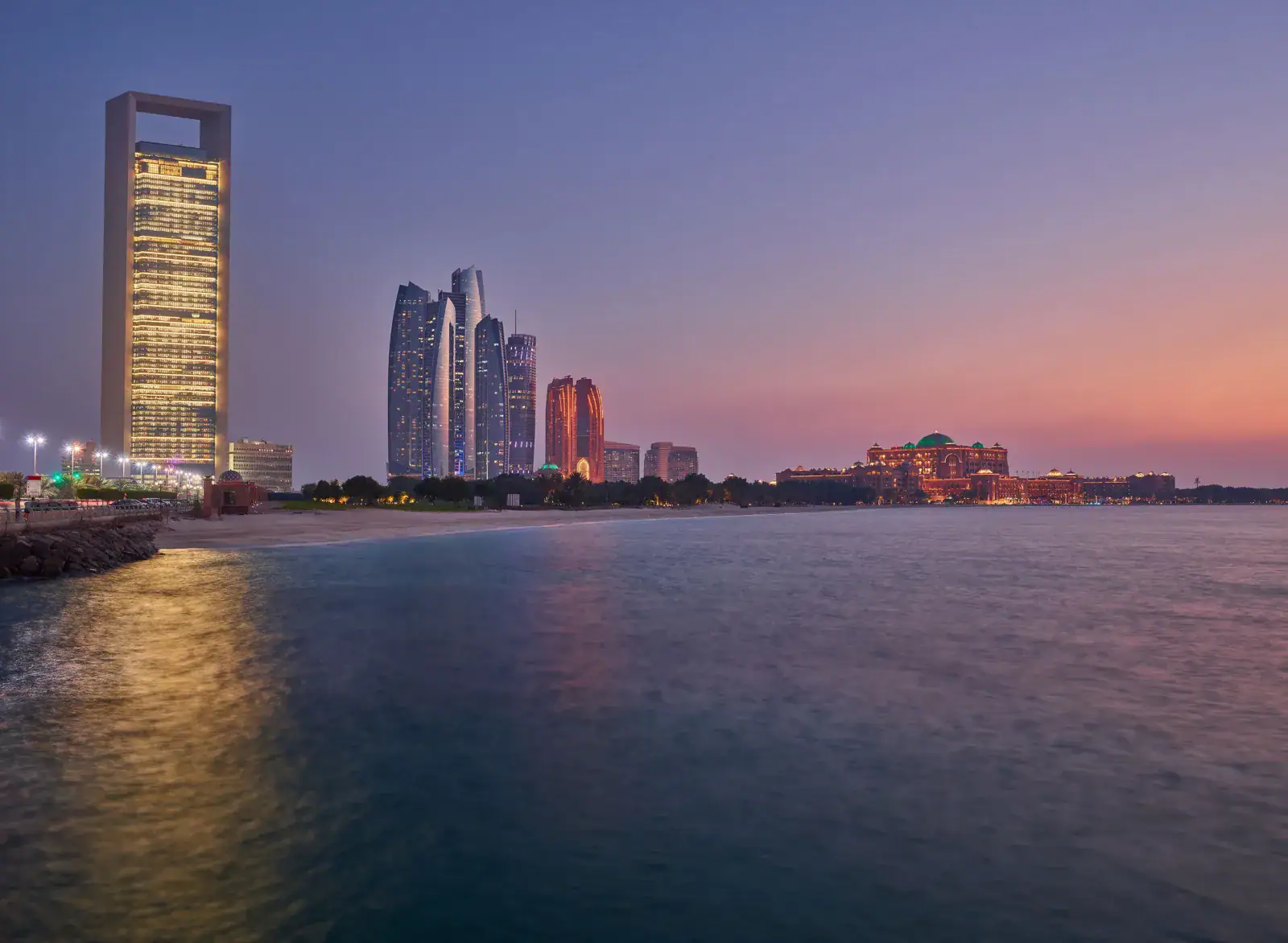 Al Corniche Abu Dhabi at sunset, with ADNOC HQ, Etihad Towers and Emirates Palace on the waterfront
