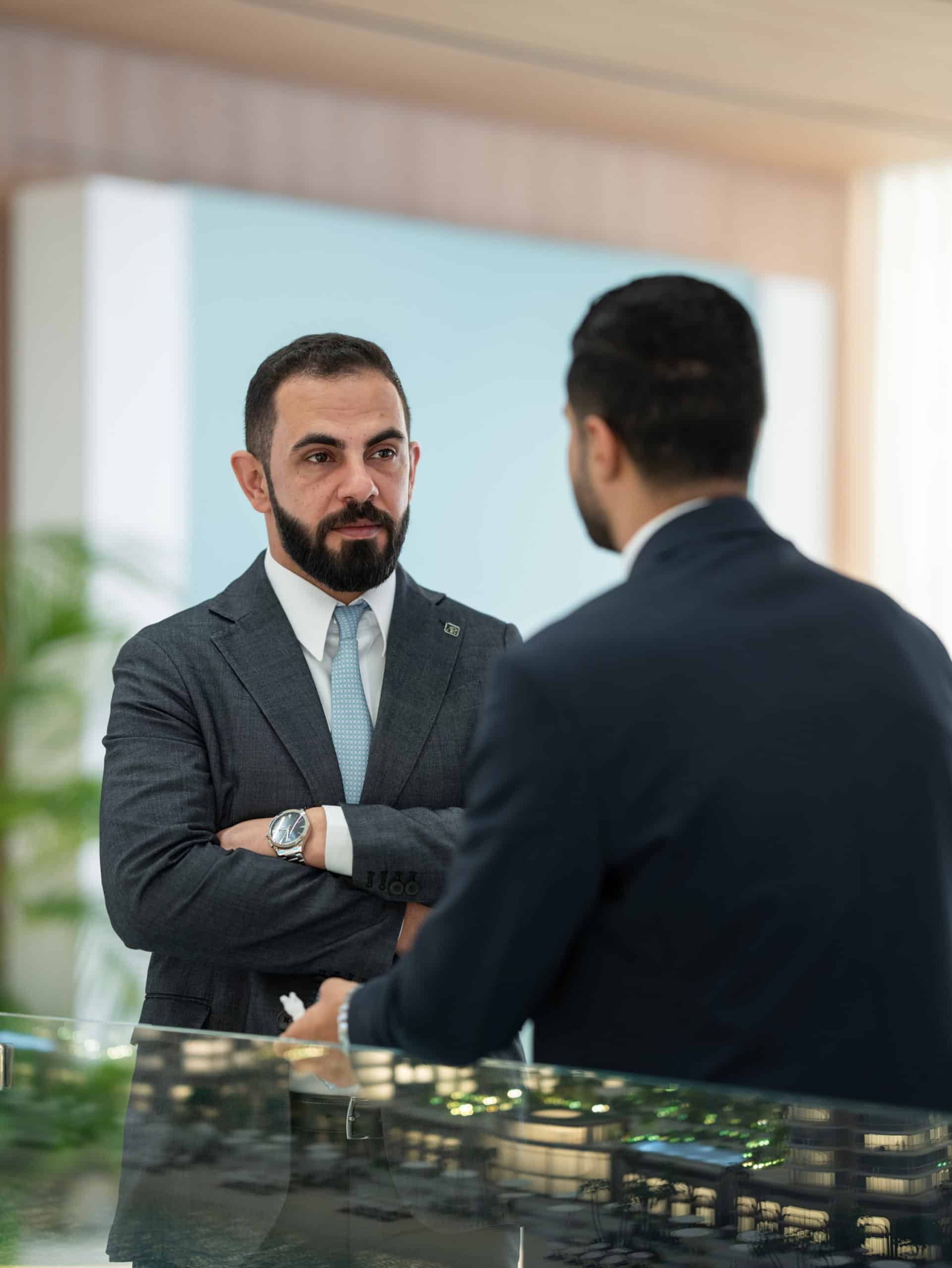 Address Point Properties consultant discussing an Aldar project beside the masterplan model
