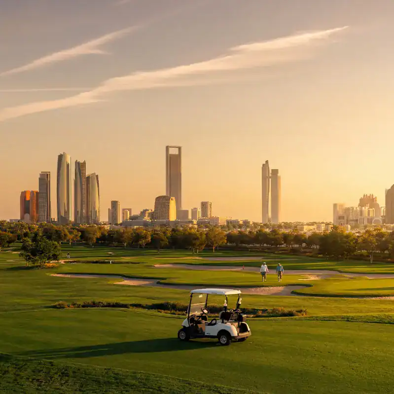 Golf course with the Abu Dhabi skyline at Hudayriyat Golf Estates by Modon